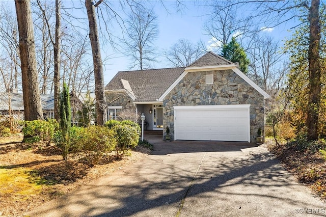 view of front facade with an attached garage, stone siding, concrete driveway, and roof with shingles