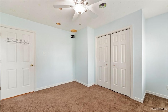 unfurnished bedroom featuring carpet floors, ceiling fan, and a closet