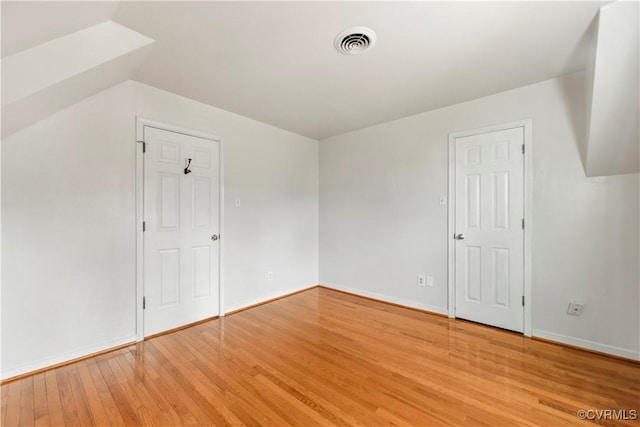 additional living space with lofted ceiling and light hardwood / wood-style flooring