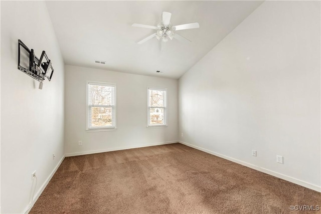 carpeted spare room featuring vaulted ceiling and ceiling fan