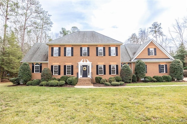 view of front of property with a front yard and brick siding