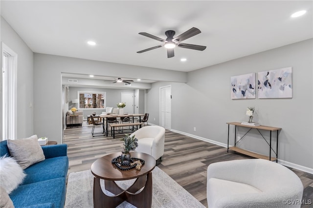 living room with wood-type flooring and ceiling fan