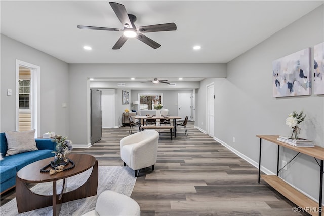 living room featuring ceiling fan and dark hardwood / wood-style flooring