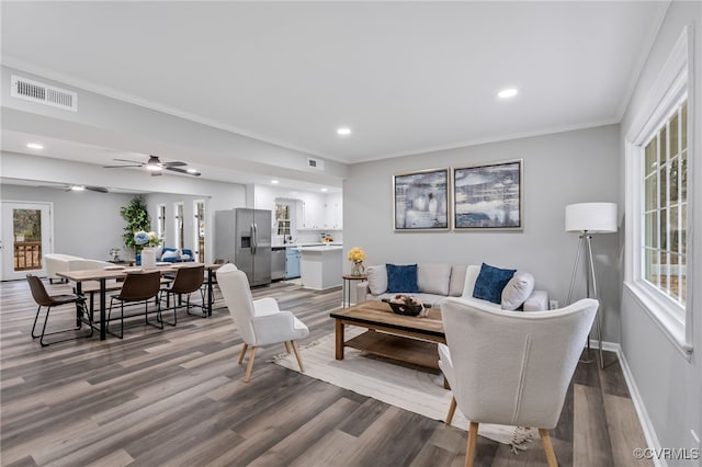 living room featuring hardwood / wood-style flooring, crown molding, and ceiling fan