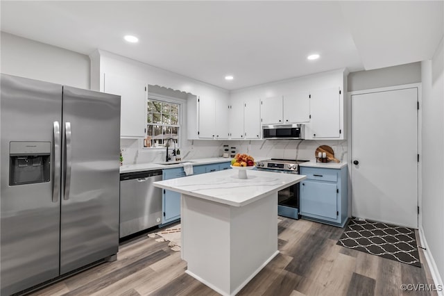 kitchen featuring white cabinetry, sink, stainless steel appliances, and a center island