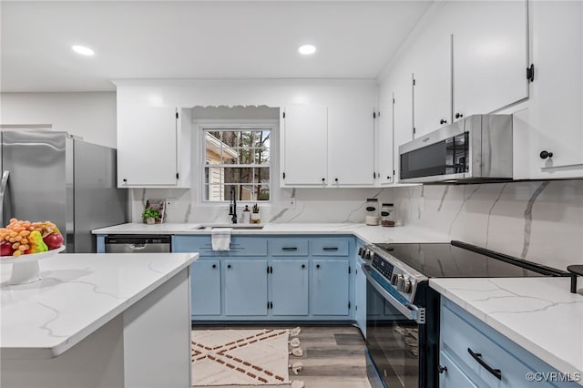 kitchen featuring white cabinetry, appliances with stainless steel finishes, sink, and blue cabinetry