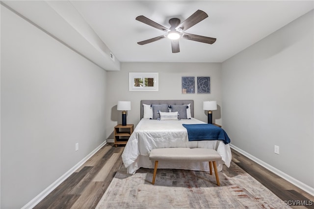 bedroom with dark hardwood / wood-style floors and ceiling fan