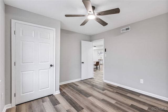 unfurnished bedroom with ceiling fan and wood-type flooring