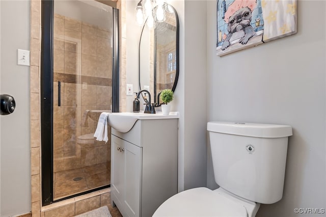 bathroom with vanity, toilet, and a shower with shower door