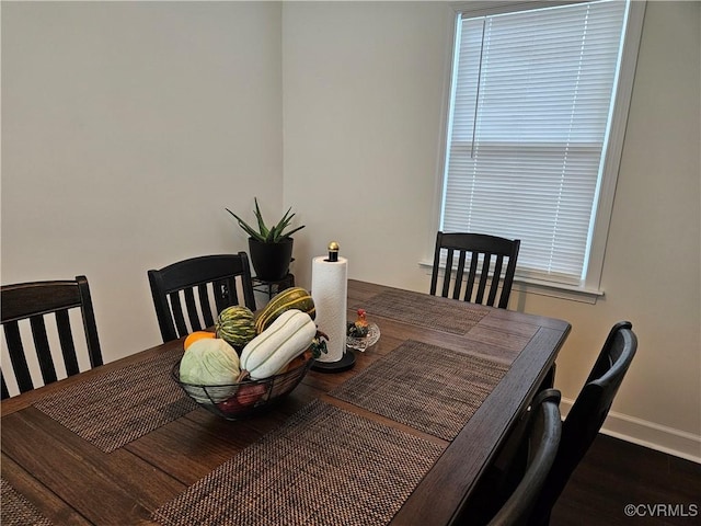 dining area with baseboards and wood finished floors