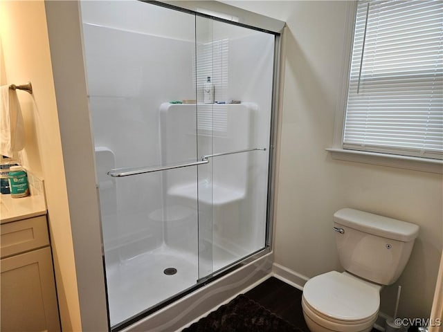 full bathroom featuring a shower stall, toilet, wood finished floors, and baseboards