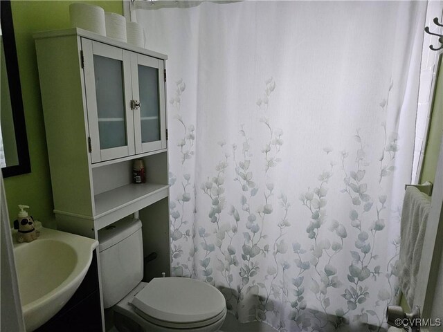 full bath with curtained shower, toilet, and vanity