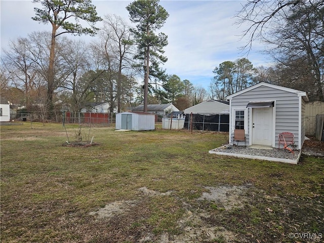 view of yard with an outdoor structure, a shed, and a fenced backyard