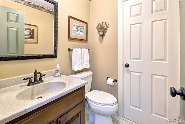 half bath with toilet, tile patterned flooring, and vanity