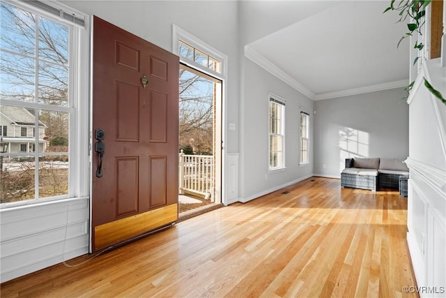 entrance foyer with crown molding and light hardwood / wood-style floors