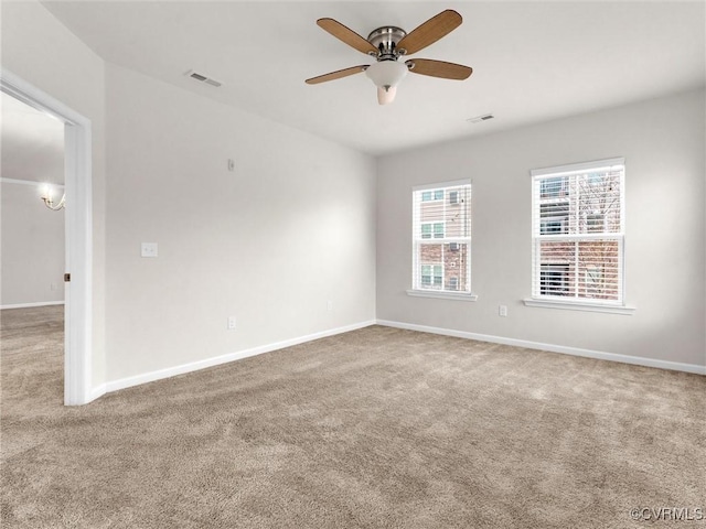 spare room featuring visible vents, baseboards, ceiling fan, and carpet floors