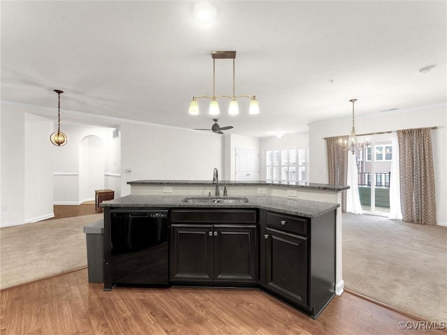 kitchen with open floor plan, dishwasher, an island with sink, and a sink
