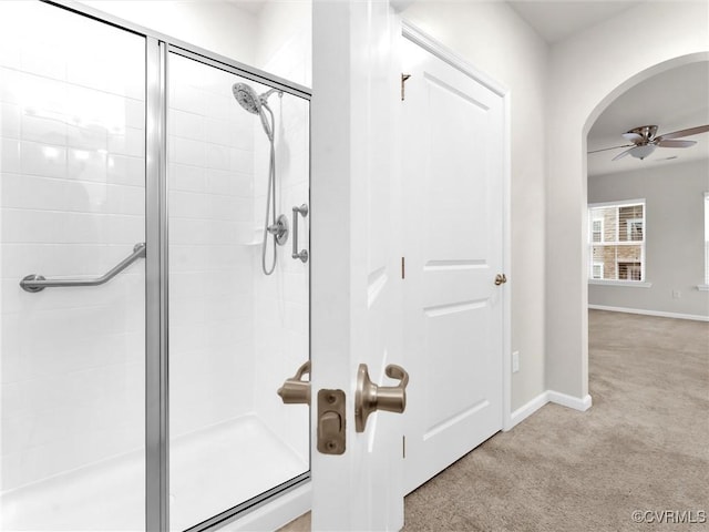 bathroom with baseboards, ceiling fan, and a tile shower