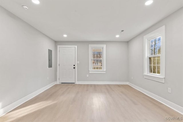 empty room with recessed lighting, plenty of natural light, electric panel, and baseboards