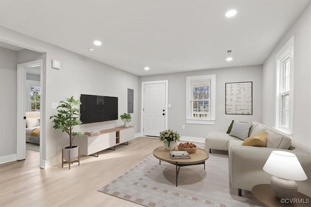 living room with baseboards, a wealth of natural light, light wood-style flooring, and recessed lighting