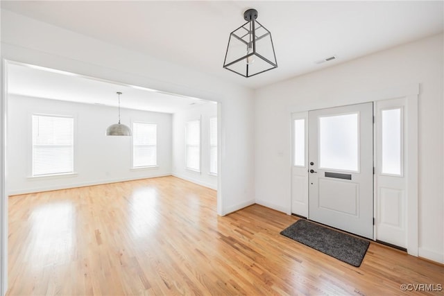 foyer with baseboards, visible vents, and light wood finished floors