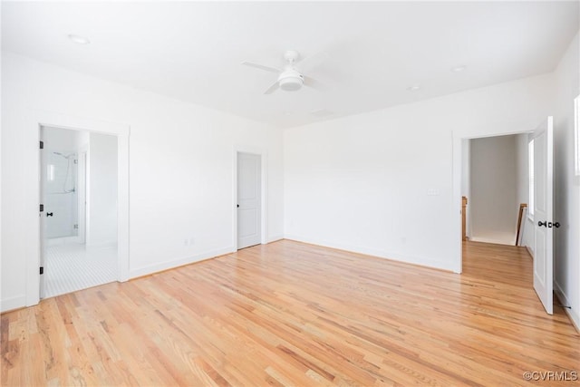 spare room with light wood-style floors, ceiling fan, and baseboards