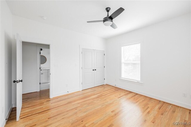 unfurnished bedroom with light wood-style floors, a ceiling fan, baseboards, and a closet