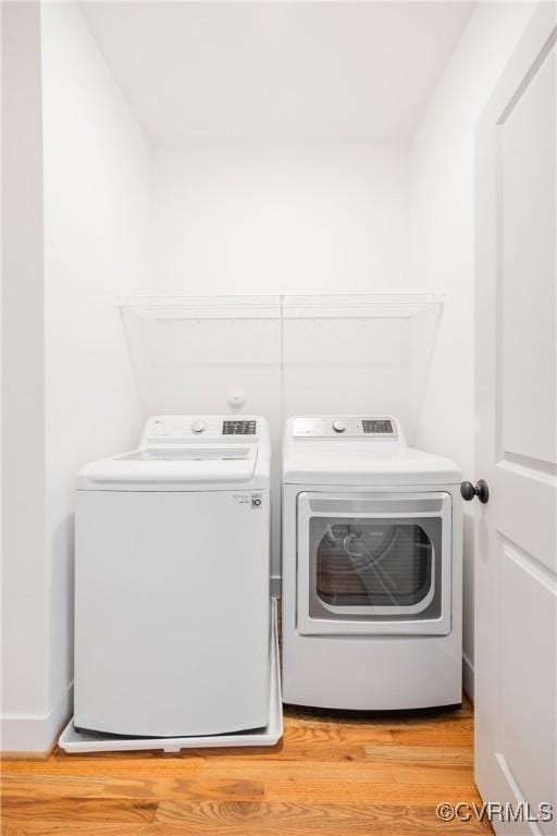 washroom with laundry area, light wood finished floors, and washer and dryer