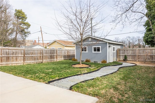 view of yard with a fenced backyard and an outbuilding