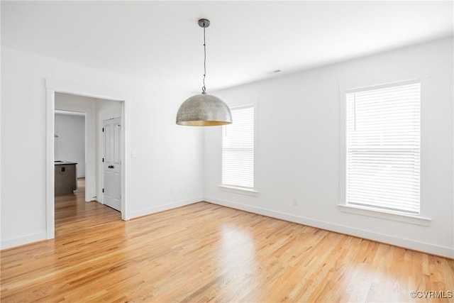 unfurnished dining area featuring light wood-style floors and baseboards