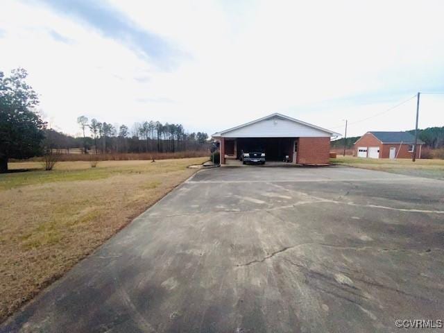 view of vehicle parking featuring a garage and a lawn