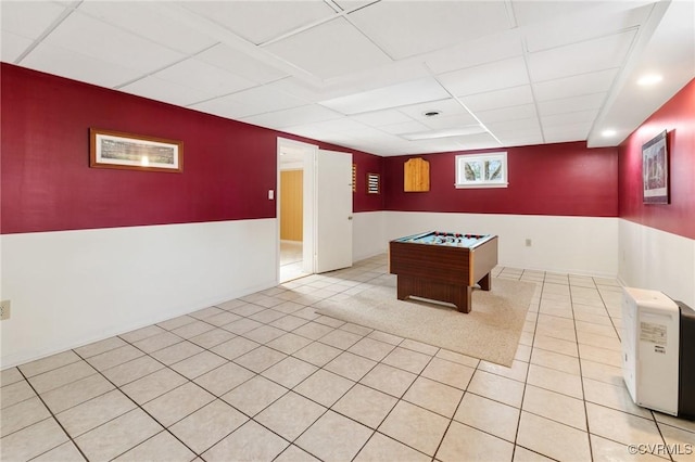 game room with light tile patterned floors and a paneled ceiling