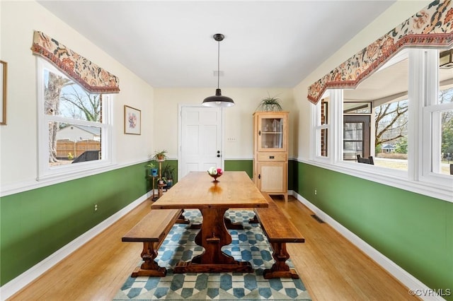 dining area featuring wood finished floors, visible vents, and baseboards