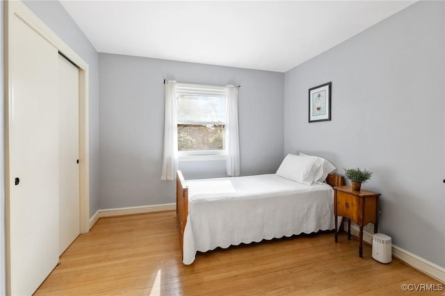 bedroom featuring baseboards, a closet, and light wood-style floors