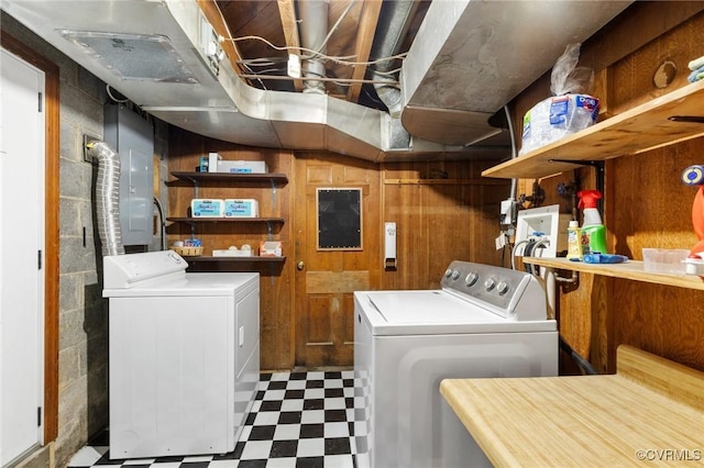 washroom with light floors, wood walls, laundry area, electric panel, and independent washer and dryer