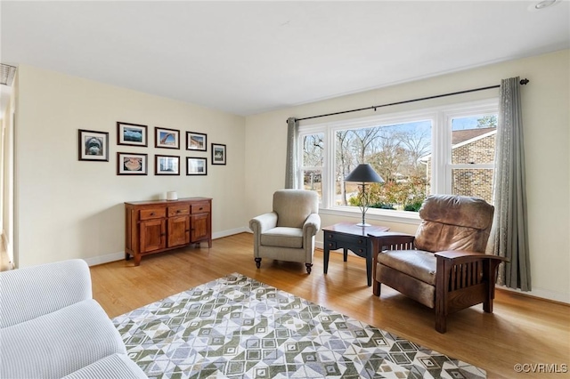 living area featuring baseboards and light wood-style floors