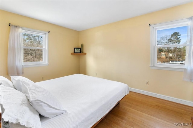 bedroom featuring baseboards and wood finished floors