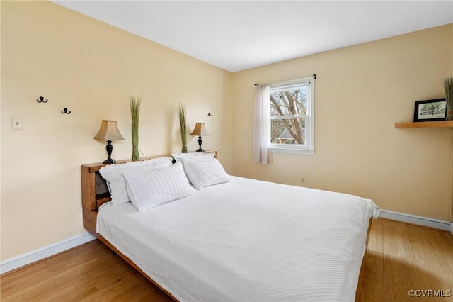 bedroom with wood finished floors and baseboards