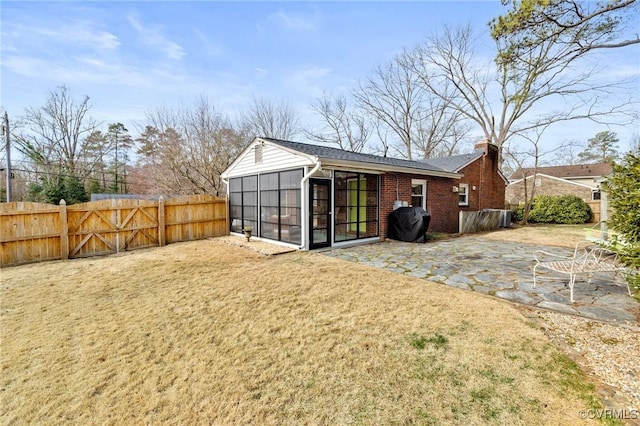 view of outdoor structure with a sunroom and a fenced backyard