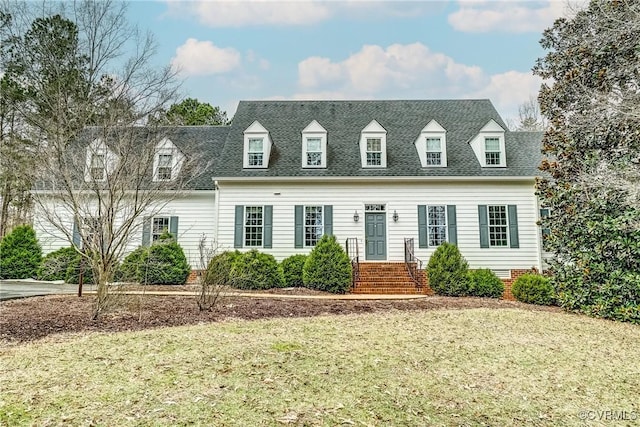 cape cod-style house with a shingled roof, crawl space, and a front lawn