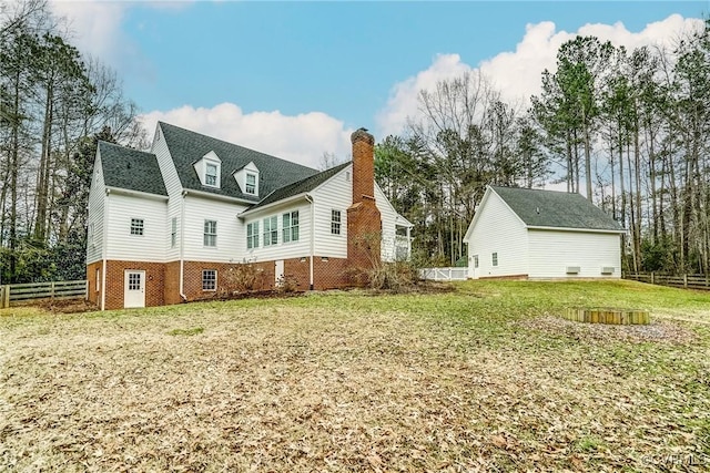 view of side of property featuring a yard, a chimney, and fence