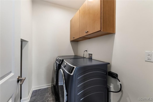 laundry area with cabinet space, baseboards, and washer and clothes dryer