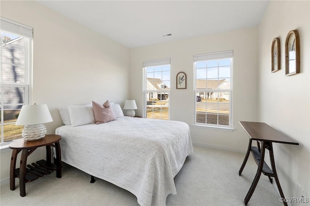 bedroom featuring light carpet, visible vents, and baseboards