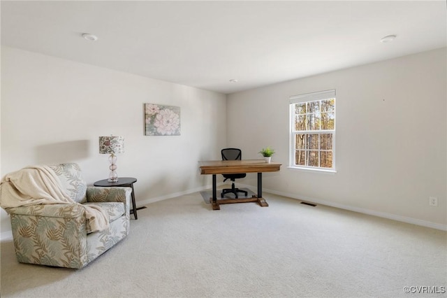 carpeted office space featuring visible vents and baseboards