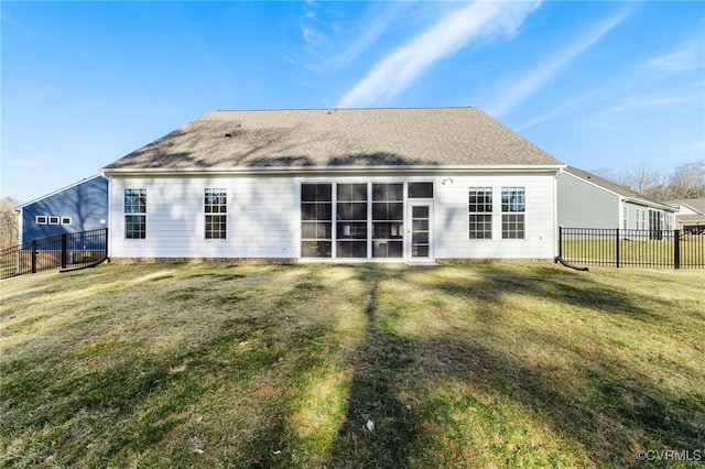 rear view of property with a lawn and fence