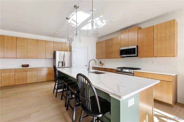 kitchen featuring tasteful backsplash, a kitchen bar, stainless steel appliances, and a sink