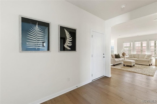 unfurnished living room featuring baseboards and wood finished floors