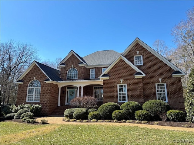 traditional-style home with a front yard and brick siding