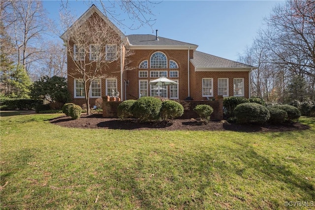 view of front of home featuring a front yard and brick siding