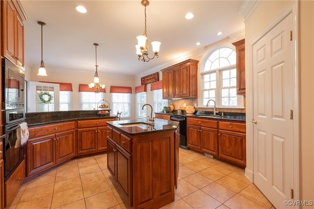 kitchen featuring a chandelier, a kitchen island with sink, a sink, and black appliances